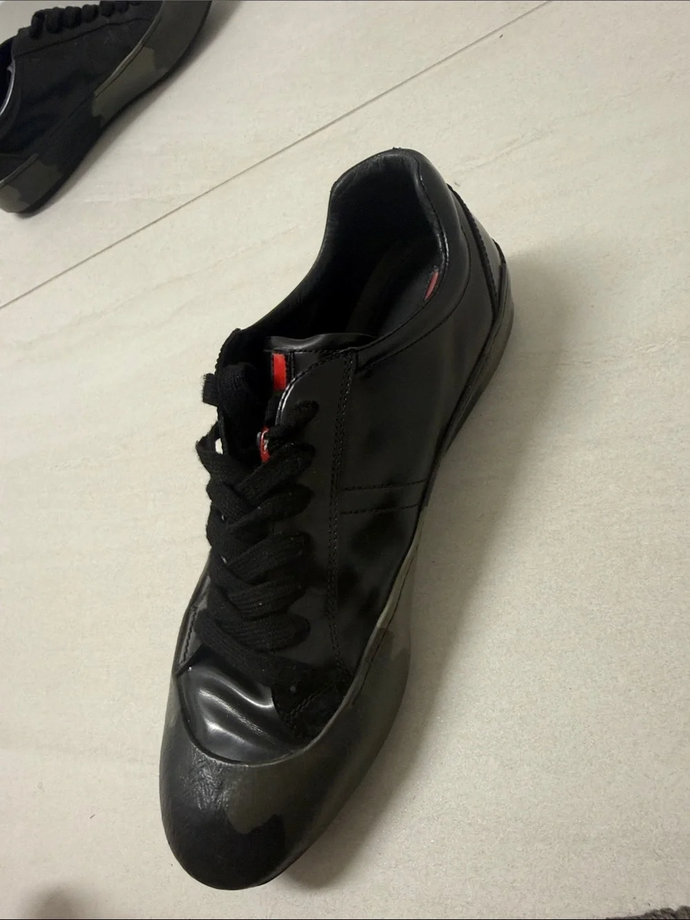 Prada Black Low-Top Leather Sneaker with Red Tongue Accent